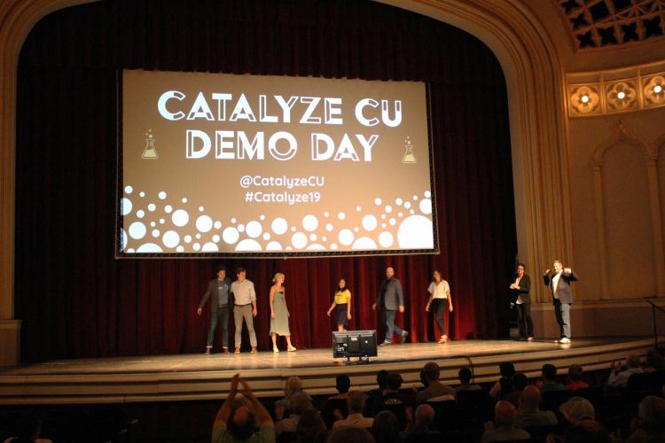 Catalyze participants walk on stage at Demo Day