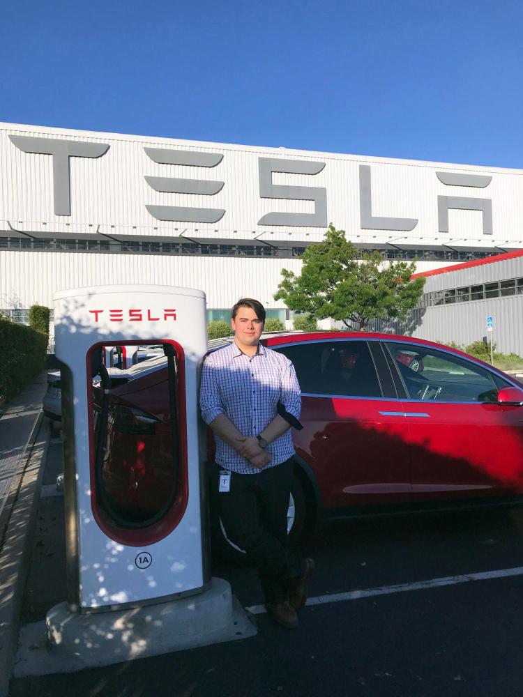 Cam Humphreys stands outside Tesla factory in California.