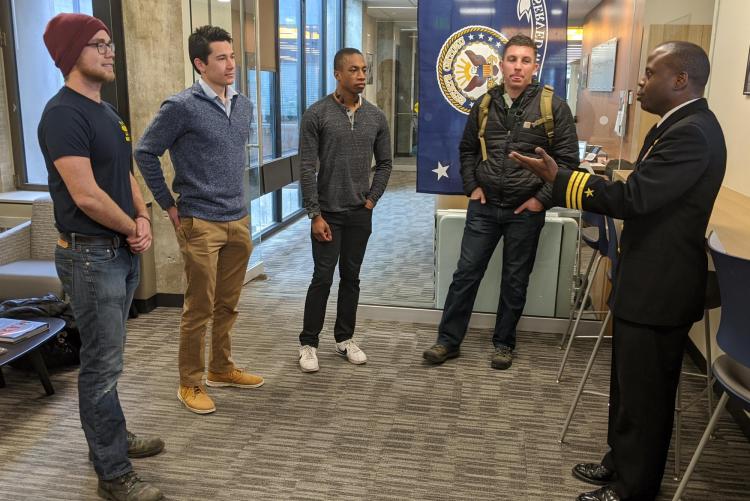 Devin Lindsey and 3 other students chat with U.S. Navy Commander Robert “Mac” McFarlin during his visit to CU Engineering.