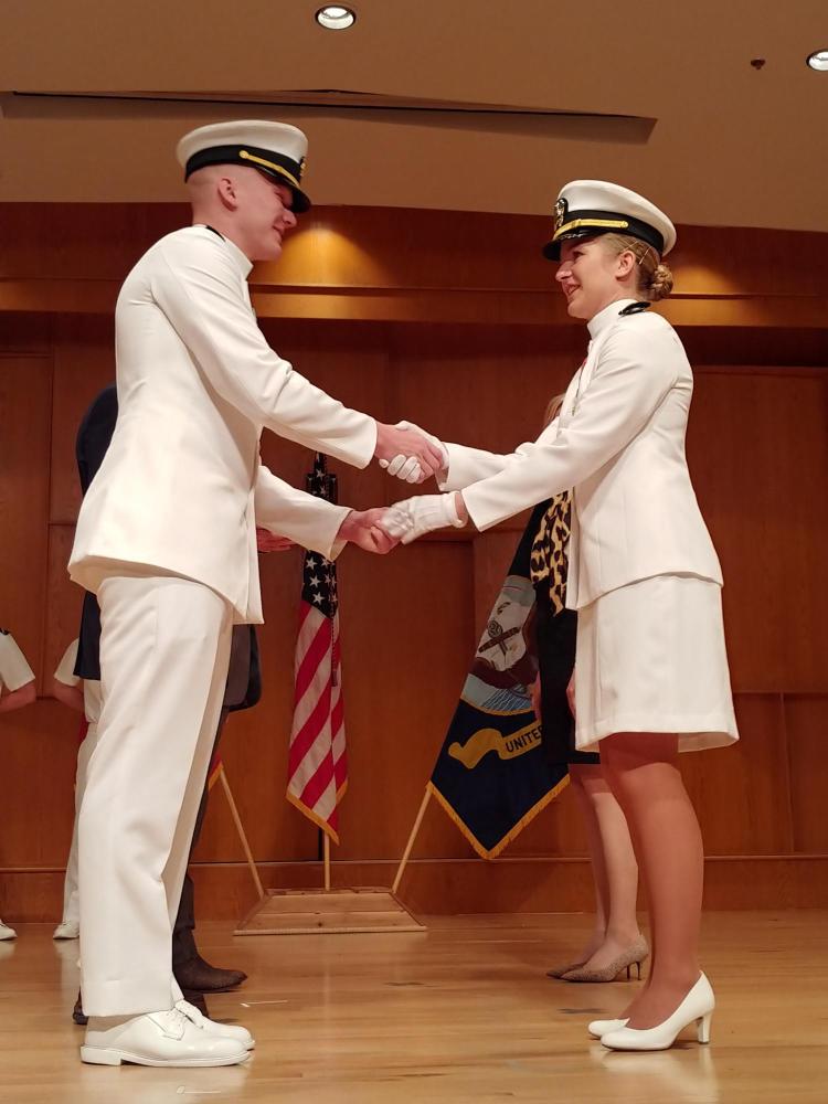 Ensign Gemma Nowak renders her first handshake and challenge coin exchange as a new Navy officer.