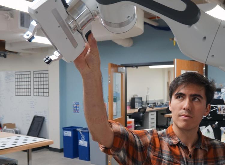 A student working with the robotic arm in the lab