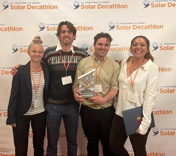 Student members of the solar decathlon team standing with their award