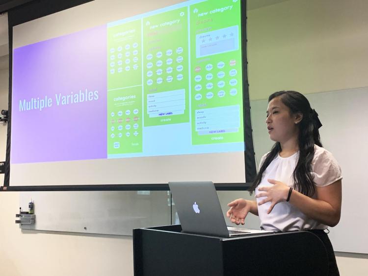 Teresa Lim gives a presentation on her work with a power point slide