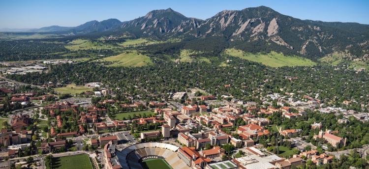 An aerial view of campus, with the Flatirons in the background