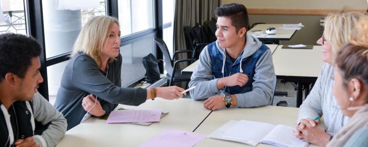 Professor with students at a table.