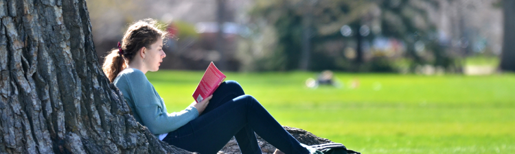 Woman sitting under a tree reading