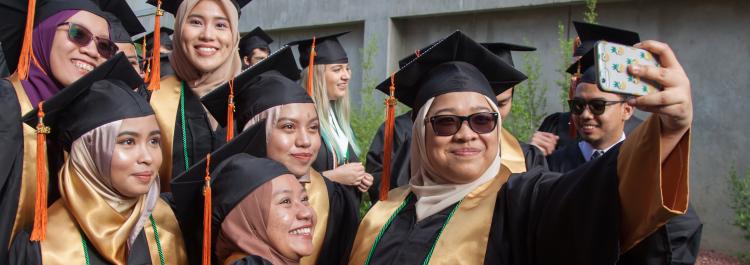 Female students pose for selfie during graduation