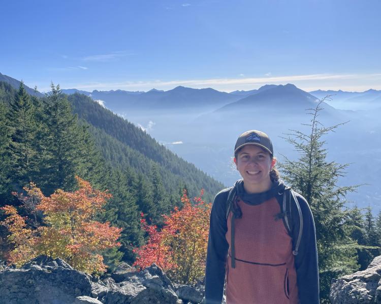 photo of Mia Miller with a background of treelined mountains