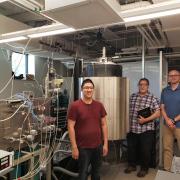 Justin Chan, Al Weimer and Kent Warren stand in the Weimer Lab