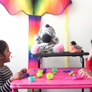 Two children chat with the MindScribe stuffed zebra. 