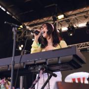Dafna singing onstage at a show, behind her keyboard