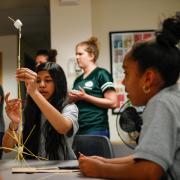 female middle school students tackle pasta and marshmallow challenge