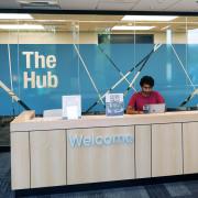 A student ambassador staffs the front desk of the Hub