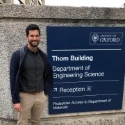 Alec Thomas standing next to a sign at Oxford 