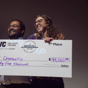 Students holding a check on stage 