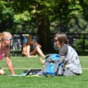 Students sitting on grass on campus 