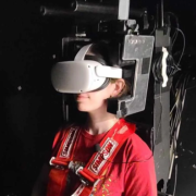 Graduate student Taylor Lonner dons a virtual reality headset inside the Tilt-Translation Sled