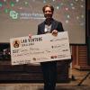 Man standing and holding a check for $125,000 at the Lab Venture Challenge event.