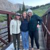 Kate Lamb stands between two other YSSRP participants on a bridge with mountains in the background.