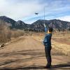 Alex Lubar reads the anemometer measurements while Wilson Hughes flies a drone at CU Boulder South Campus.