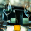 An air purifier the size of a water bottle sits among wine glasses on a restaurant table