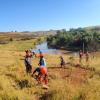 The team working at the bridge site with pickaxes and shovels. 