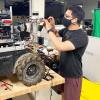 Dan Torres wears a mask while working on one of the DARPA Subterranean Challenge robots