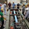 A group of water experts gather around the seismic testing equipment in the CIEST lab. 