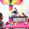 Two children chat with the MindScribe stuffed zebra. 