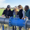 Students working in the field on pipes