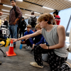 Middle school student shown petting the robotic dog, spot.