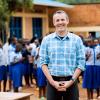 Professor Evan Thomas stands next to a water treatment system installed at a school in Rwanda.