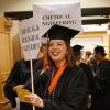 Woman smiling as students line up for graduation.