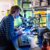 Graduate student at microscope in robotics lab