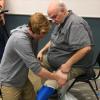Max Armstrong helps an amputee put on his new prosthetic leg. 