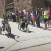 Two students race their vehicles down a sidewalk as their classmates look on