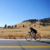 A woman rides her bike along a Boulder backroad. 