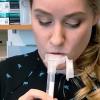 A researcher provides a saliva sample for a rapid COVID-19 test in a lab 