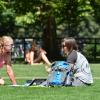 Students sitting on grass on campus 