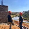 Two team members discuss construction near a bridge abutment in Swaziland.