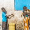 Two children fill water containers from a groundwater supply system in Turkana, Kenya