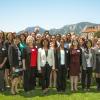The Women in Aerospace Symposium standing for a group photo outside with the Flatirons in the background.