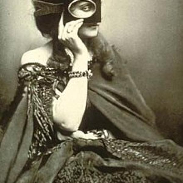Photo of a woman in a dress covering her face with a mask