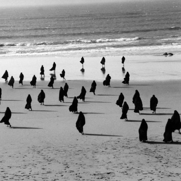Figures walking on a beach
