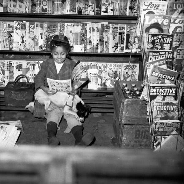 A young girl reading a magazine outside