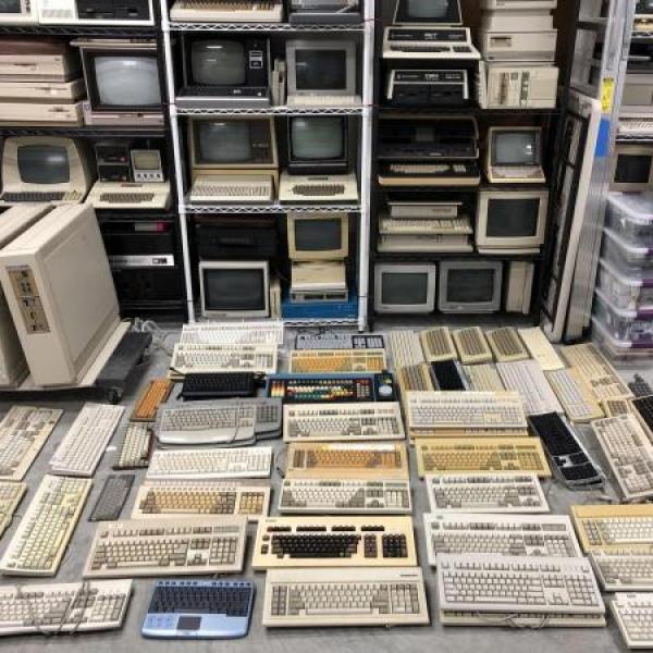 Stacks of computers and keyboards on shelves