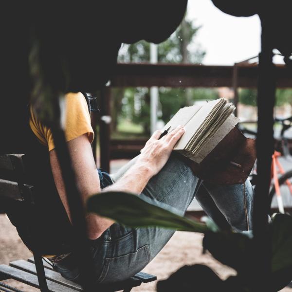 Woman on park bench with a notebook
