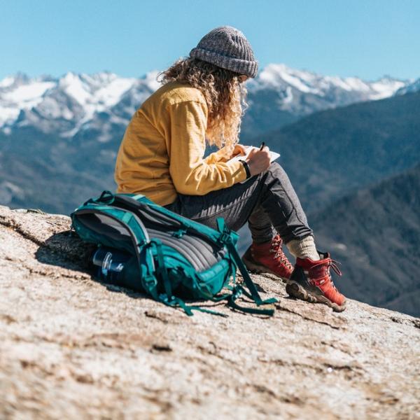 Woman writing on a mountaintop