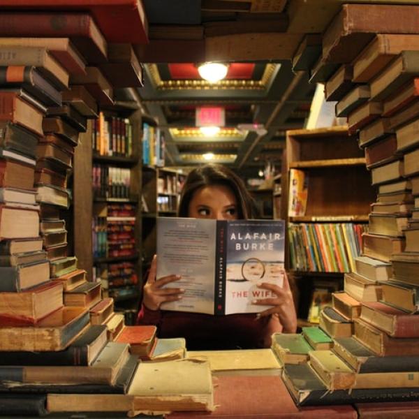 WOMAN SURROUNDED BY BOOKS