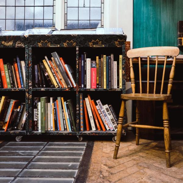 A wooden chair next to a bookshelf